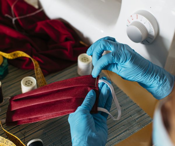 Close-up view of a woman's hands sewing a cloth face mask